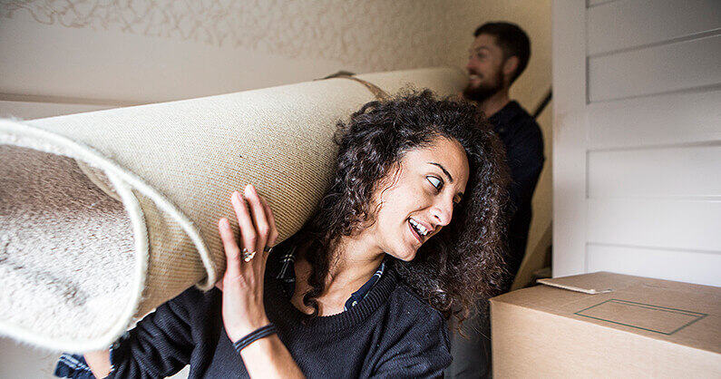 Man and woman moving a carpet