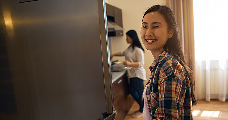 Woman smiling and moving fridge