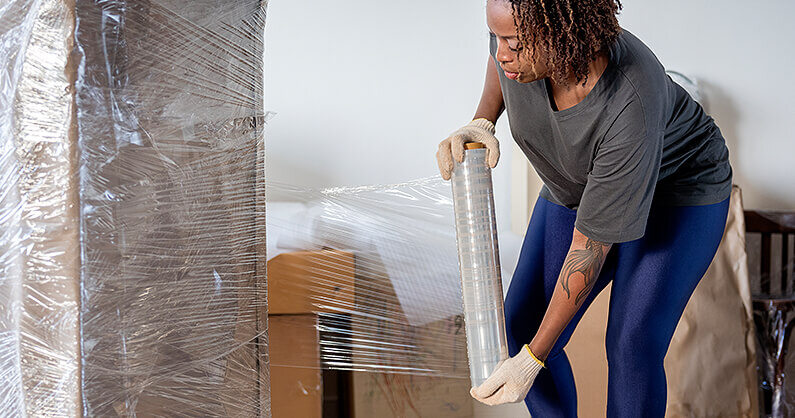 Woman packing furniture and wrapping it