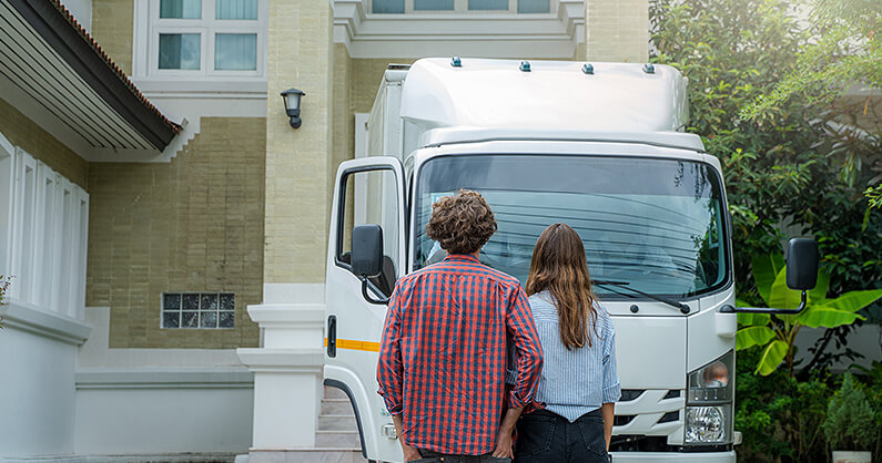 Couple looking at truck when moving at Christmas